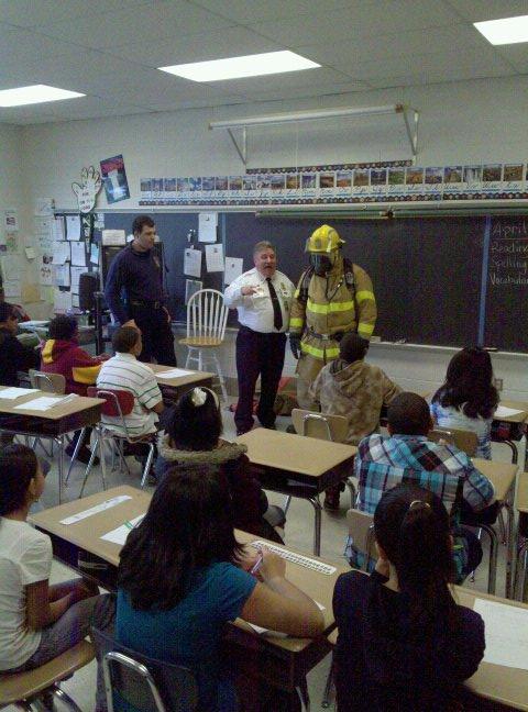 Chief Chornock speaks to a class of 4th graders with Kevin Younkins (in turnout gear), Paramedic Lindberg, and Robert McHenryIII